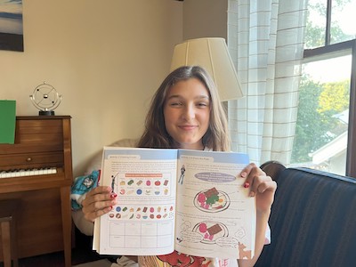 Abbie (one of the kids who shared the experiences) holding a new workbook for kids that is going to be published in October.